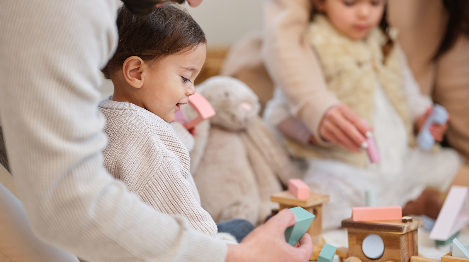 Toddler playing with Baby Steps coloured wooden blocks.
